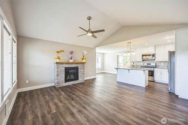 178 Pacific Blvd NW, Ocean Shores, WA 98569 - kitchen featuring white cabinets, stainless steel appliances, a ceiling fan, open floor plan, and a breakfast bar area