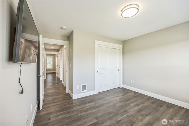 178 Pacific Blvd NW, Ocean Shores, WA 98569 - unfurnished bedroom with baseboards, dark wood-type flooring, visible vents, and a closet