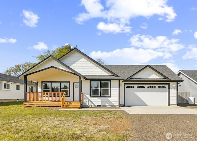 178 Pacific Blvd NW, Ocean Shores, WA 98569 - view of front facade featuring a shingled roof, a front lawn, driveway, a porch, and a garage