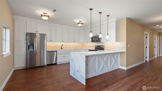 kitchen featuring baseboards, appliances with stainless steel finishes, decorative backsplash, and visible vents