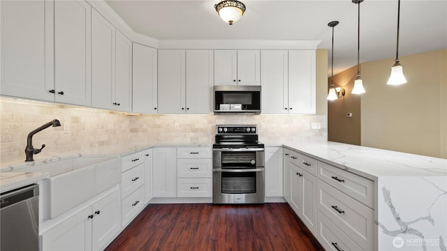 kitchen with a sink, appliances with stainless steel finishes, a peninsula, and white cabinetry