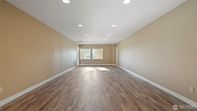 empty room featuring recessed lighting, baseboards, and wood finished floors