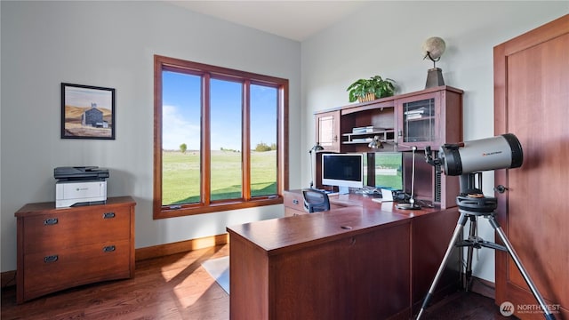 home office with baseboards, plenty of natural light, and dark wood finished floors