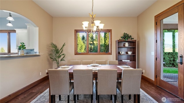 dining room with baseboards, arched walkways, dark wood-style floors, and a notable chandelier