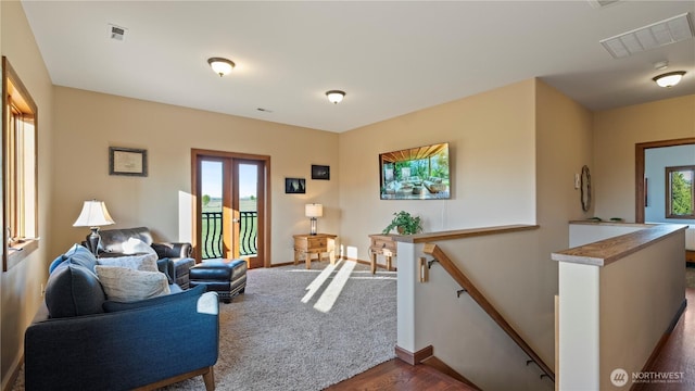 living room featuring baseboards, a wealth of natural light, and visible vents