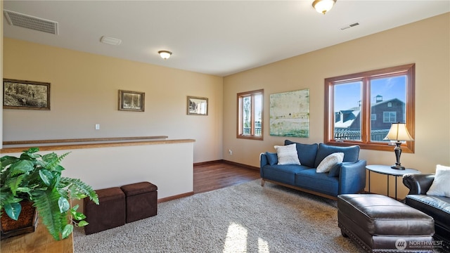 carpeted living room with baseboards and visible vents