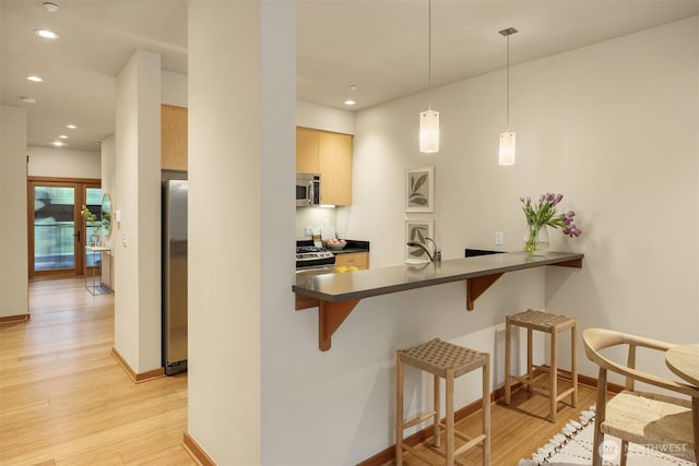 bar with recessed lighting, appliances with stainless steel finishes, baseboards, and light wood finished floors