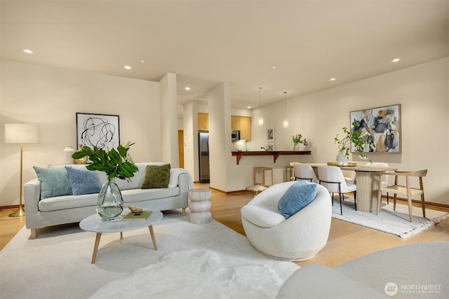living area with recessed lighting, light wood-style flooring, and baseboards
