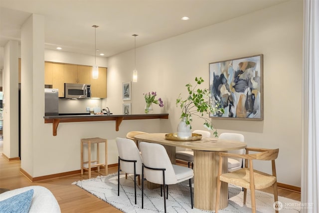 dining area featuring baseboards, recessed lighting, and light wood-style flooring