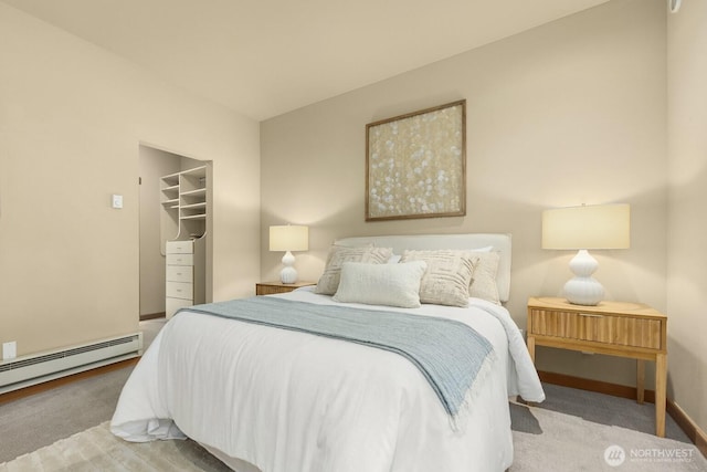 bedroom with carpet flooring, baseboards, a spacious closet, and a baseboard radiator