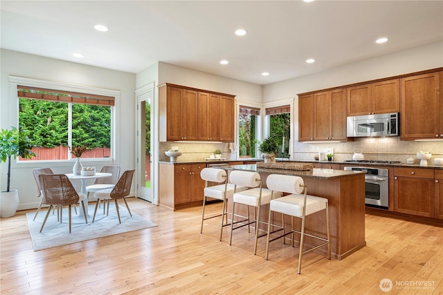 17288 NE 120th Way, Redmond, WA 98052 - kitchen featuring appliances with stainless steel finishes, a kitchen island, brown cabinets, and a kitchen bar