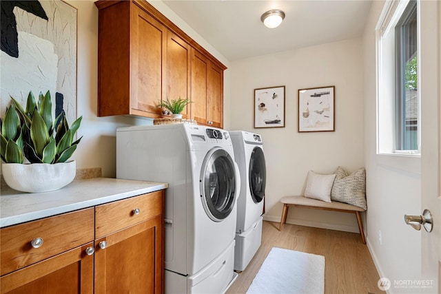 17288 NE 120th Way, Redmond, WA 98052 - laundry room with cabinet space, light wood-style floors, a healthy amount of sunlight, and washing machine and clothes dryer