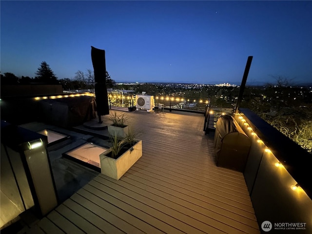 deck at night featuring ac unit