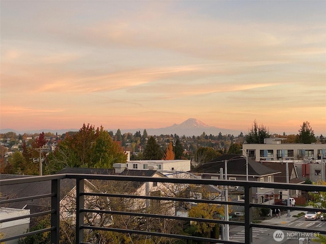 balcony at dusk featuring a mountain view