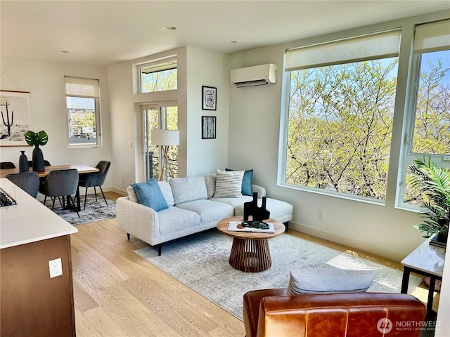 living room featuring baseboards, recessed lighting, light wood-style flooring, and a wall unit AC