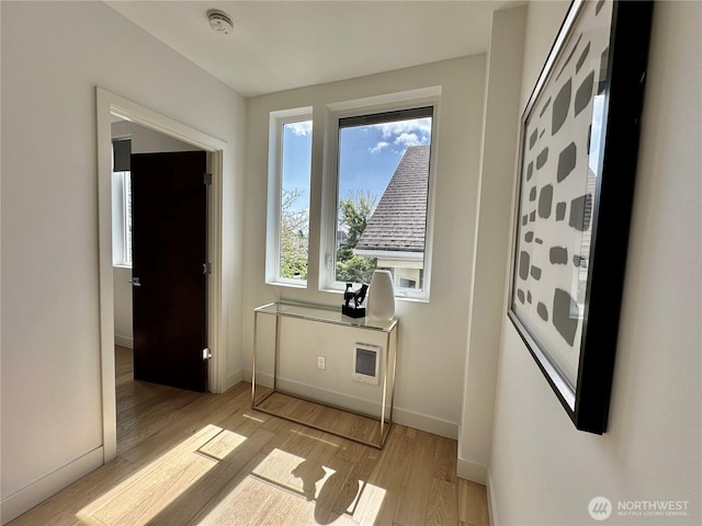 doorway to outside with baseboards and light wood-type flooring