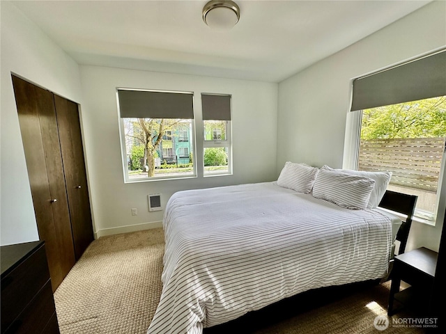 carpeted bedroom with baseboards and a closet