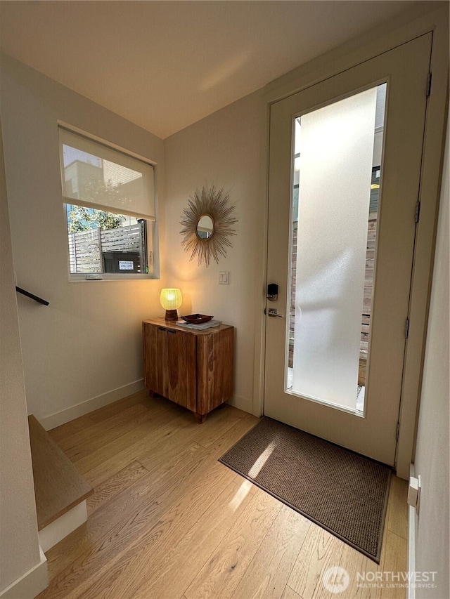 doorway with baseboards and wood finished floors