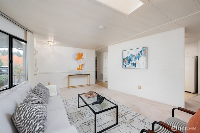 living area featuring visible vents, carpet flooring, and brick wall