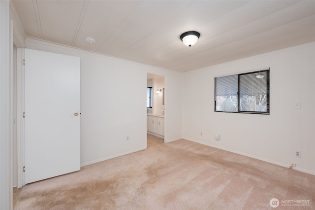 empty room with baseboards and light colored carpet