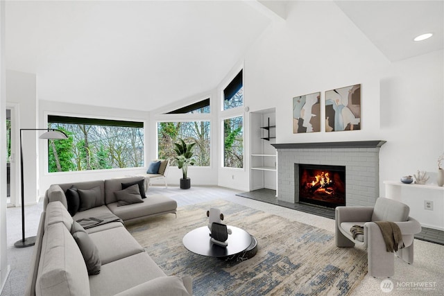 living area with a fireplace, baseboards, carpet flooring, and high vaulted ceiling