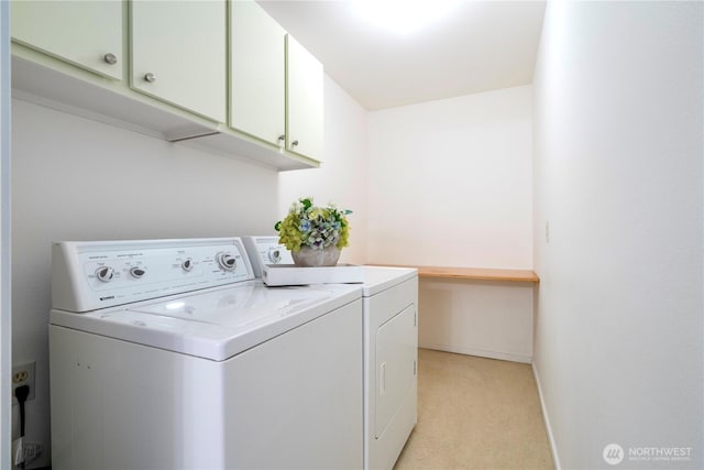 washroom featuring separate washer and dryer, light carpet, baseboards, and cabinet space
