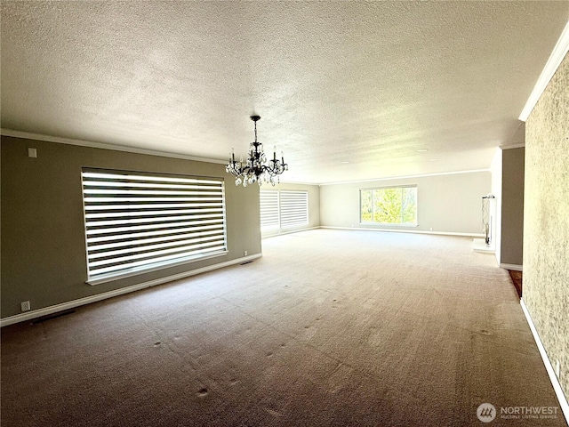 818 E Spring St, Dayton, WA 99328 - empty room featuring crown molding, a chandelier, a textured ceiling, carpet flooring, and baseboards