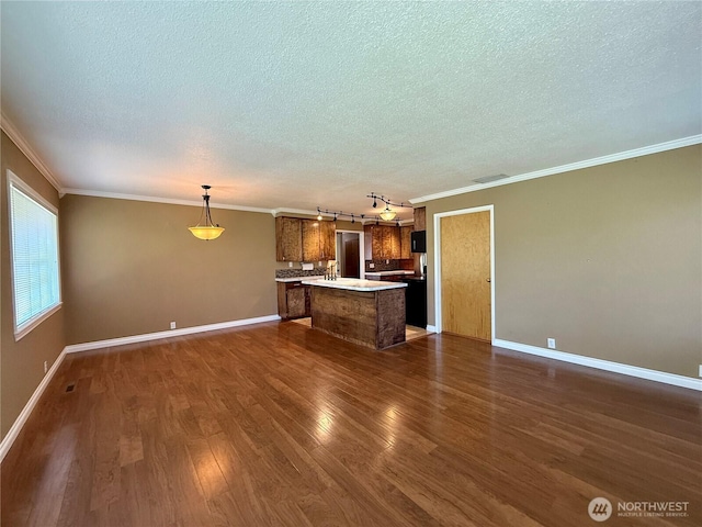 818 E Spring St, Dayton, WA 99328 - unfurnished living room featuring a textured ceiling, ornamental molding, dark wood-style flooring, and baseboards