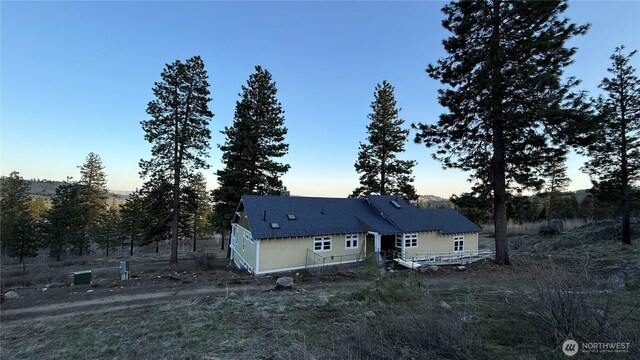 back of house at dusk featuring a wooden deck