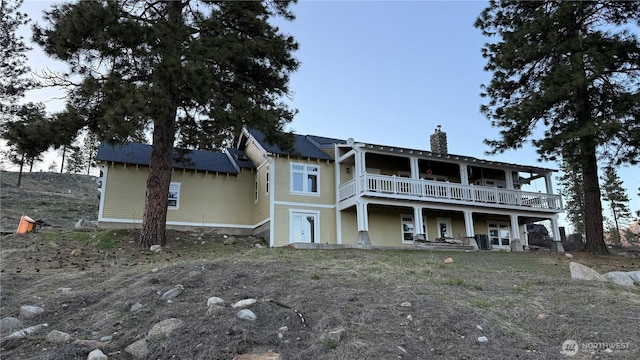 back of property with a chimney and a wooden deck