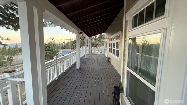 deck at dusk featuring a porch