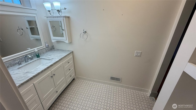 bathroom featuring baseboards, visible vents, and vanity