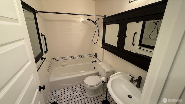 bathroom with a sink, shower / tub combination, and toilet