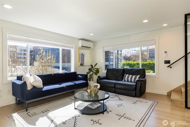 living area featuring a wall unit AC, healthy amount of natural light, wood finished floors, and recessed lighting