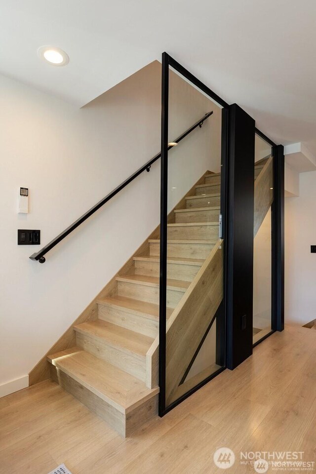 stairs featuring wood finished floors and baseboards