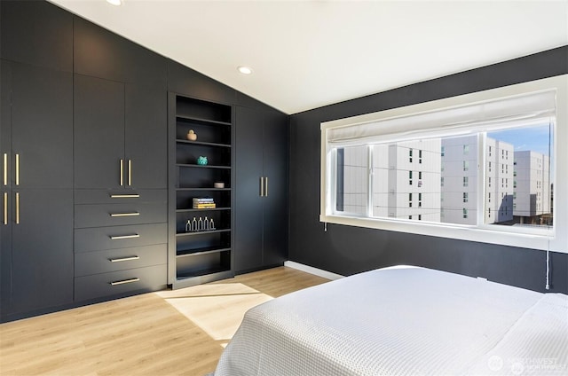 bedroom featuring vaulted ceiling, light wood-type flooring, and recessed lighting
