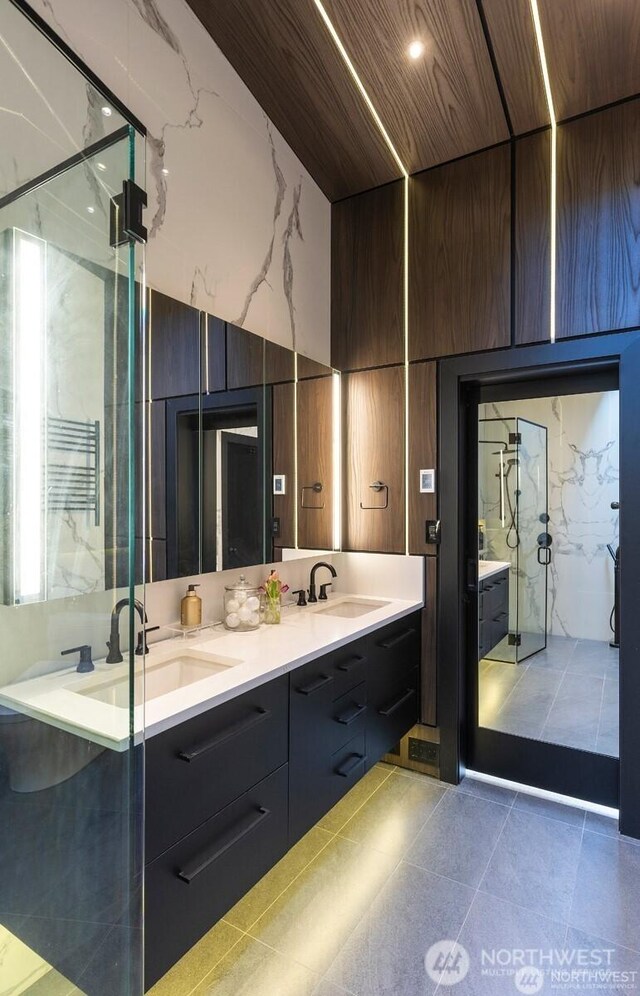 full bathroom with double vanity, a shower stall, tile patterned floors, wooden ceiling, and a high ceiling