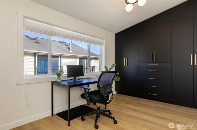 home office with light wood-style flooring and baseboards