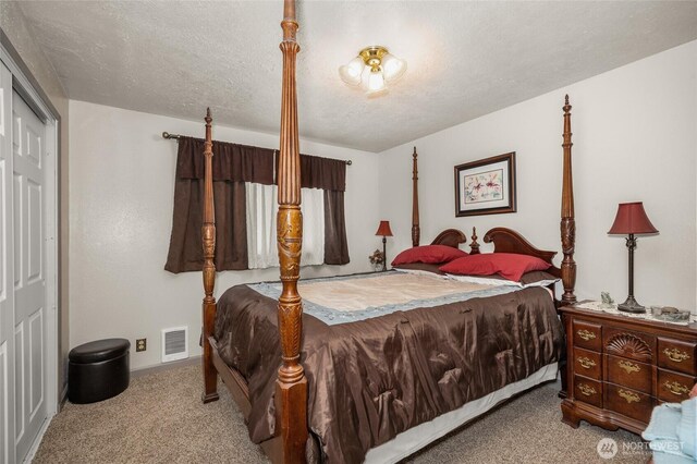 bedroom featuring carpet floors, a textured ceiling, visible vents, and baseboards