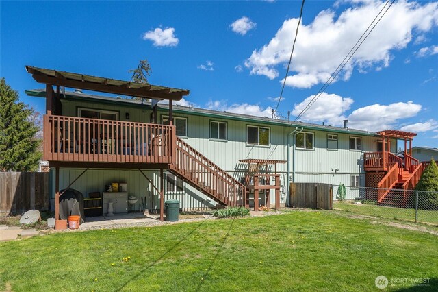 rear view of house with a wooden deck, a lawn, a fenced backyard, and stairway