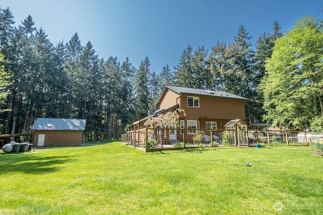 rear view of property with a lawn and an outbuilding
