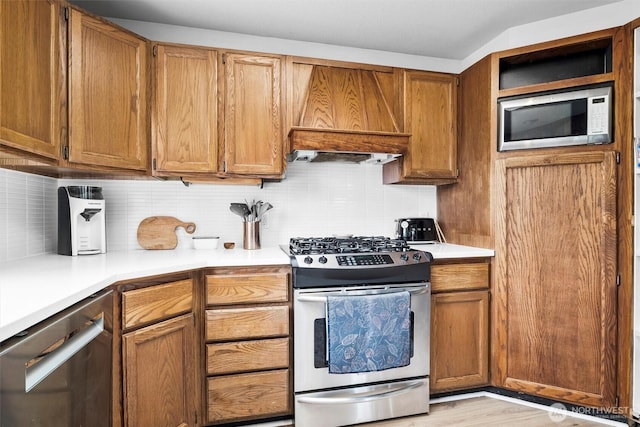 5752 Ronnie Hill Ln, Ferndale, WA 98248 - kitchen featuring brown cabinets, backsplash, stainless steel appliances, and light countertops