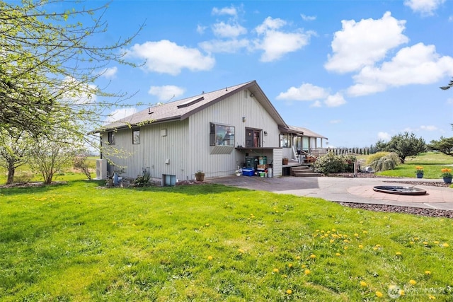 5752 Ronnie Hill Ln, Ferndale, WA 98248 - rear view of property featuring a lawn, central AC unit, a patio, and an outdoor fire pit