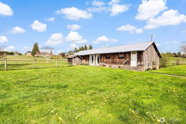 5752 Ronnie Hill Ln, Ferndale, WA 98248 - rear view of house featuring an exterior structure, an outbuilding, metal roof, a rural view, and a yard