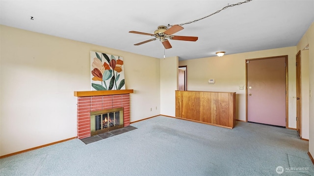unfurnished living room with carpet floors, a ceiling fan, baseboards, and a fireplace