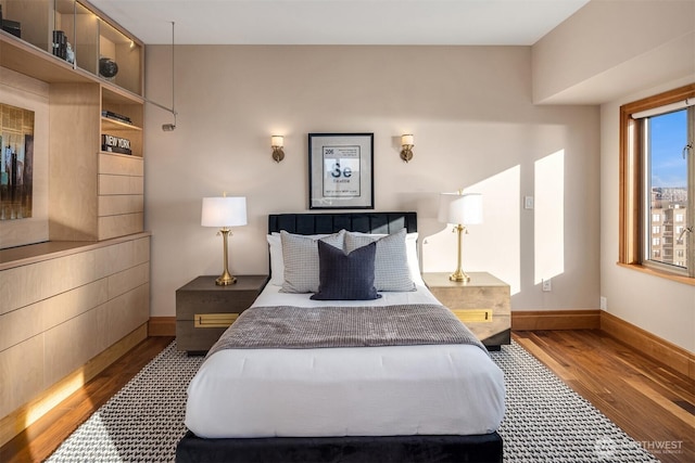 bedroom featuring baseboards and wood finished floors