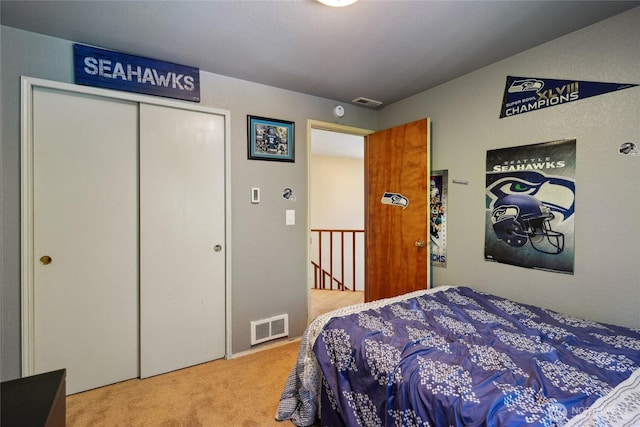 carpeted bedroom featuring a closet and visible vents
