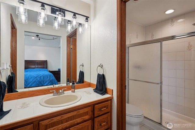 full bathroom featuring vanity, a stall shower, toilet, and connected bathroom