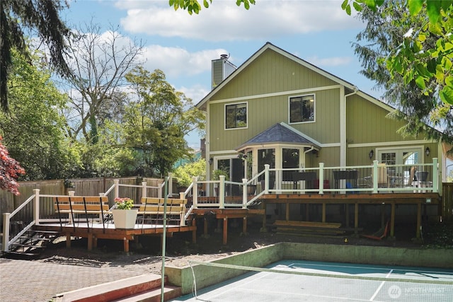 rear view of house with fence, a chimney, and a deck