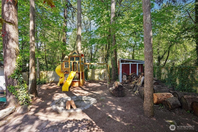 view of play area featuring fence and an outdoor structure